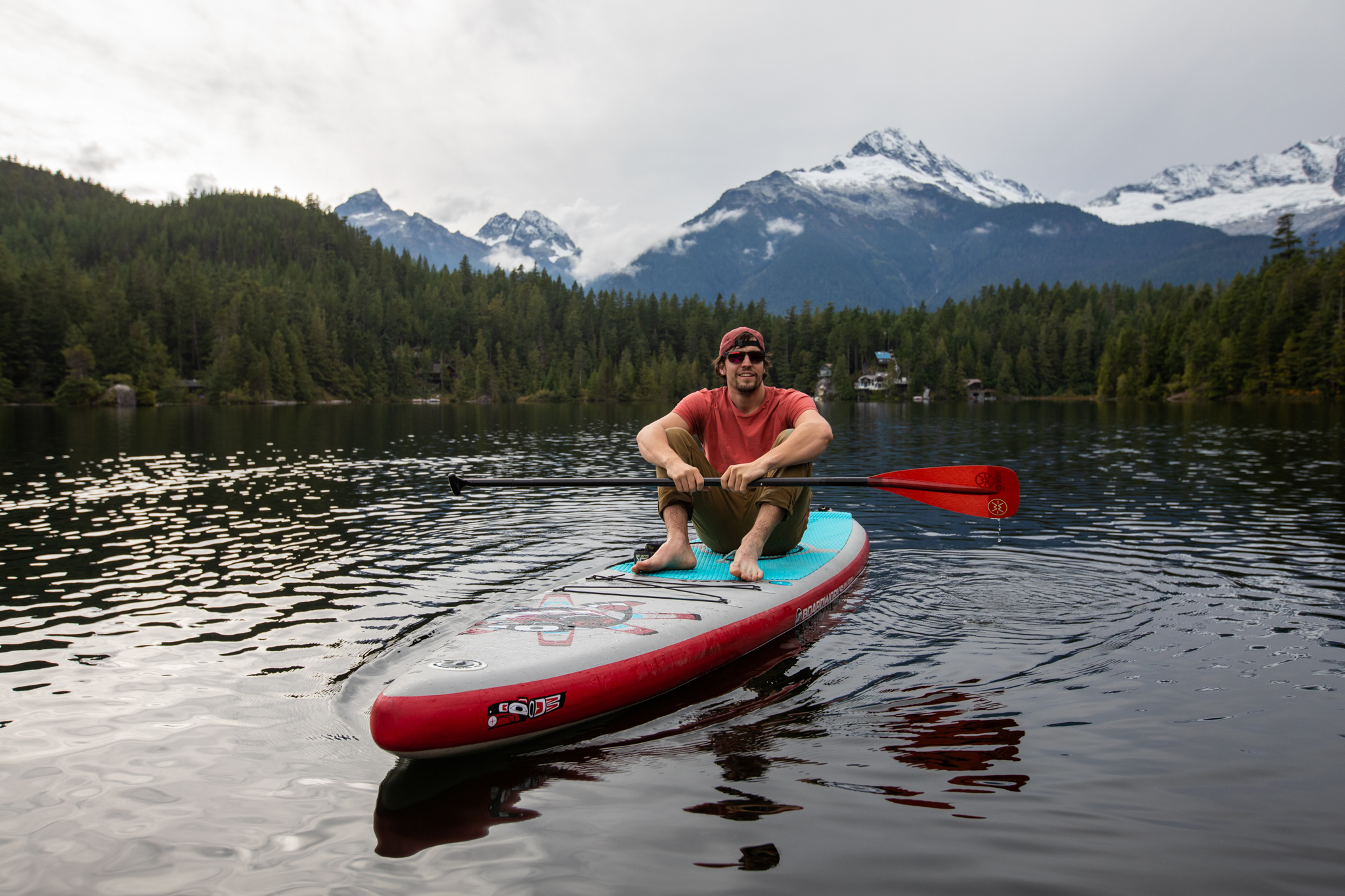 Jeremy paddleboarding on lake with mountain views